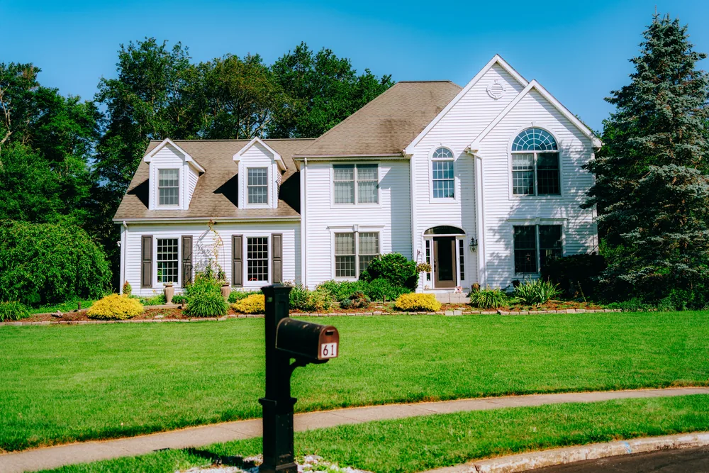 A suburban home with a striped, freshly mown front lawn